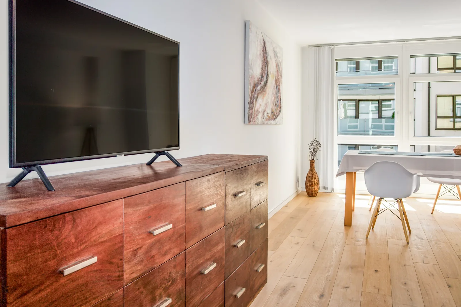 Innenraumdetail mit Sideboard, Fernseher und Blick zum Essbereich